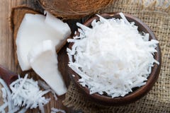 La noix de coco s'écaille dans une cuvette d'argile sur un fond rustique en bois Vue supérieure images libres de droits La noix de coco s'écaille dans une cuvette d'argile sur un fond rustique en bois Vue supérieure images libres de droits