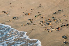 La onda golpea la playa con las piedras coloridas del guijarro - primer fotografía de archivo La onda golpea la playa con las piedras coloridas del guijarro - primer fotografía de archivo