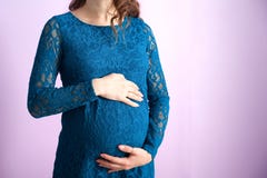 La pancia di una donna incinta in vestito blu marino fotografia stock libera da diritti La pancia di una donna incinta in vestito blu marino fotografia stock libera da diritti