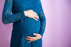 La pancia di una donna incinta in vestito blu marino fotografia stock libera da diritti La pancia di una donna incinta in vestito blu marino fotografia stock libera da diritti