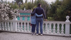 La petite fille de Fagile et un type grand marchent ensemble dans le jardin avec les magnolias de floraison le long du remblai banque de vidéos La petite fille de Fagile et un type grand marchent ensemble dans le jardin avec les magnolias de floraison le long du remblai banque de vidéos