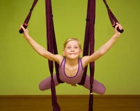La petite fille faisant le yoga aérien s'exerce, d'intérieur Photographie stock libre de droits La petite fille faisant le yoga aérien s'exerce, d'intérieur Photographie stock libre de droits