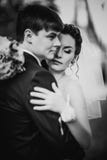 La photographie blanche noire épousant de beaux jeunes couples se tiennent sur la forêt de fond Image stock La photographie blanche noire épousant de beaux jeunes couples se tiennent sur la forêt de fond Image stock