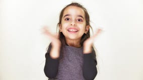 La piccola ragazza allegra sveglia sorride ed applaude le sue mani, si rallegra, fps bianchi del fondo 50 stock footage La piccola ragazza allegra sveglia sorride ed applaude le sue mani, si rallegra, fps bianchi del fondo 50 stock footage