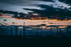 La pista de tierra del camino de las líneas eléctricas con el cielo dramático se nubla el fondo imágenes de archivo libres de regalías La pista de tierra del camino de las líneas eléctricas con el cielo dramático se nubla el fondo imágenes de archivo libres de regalías