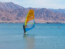 La planche ? voile sur le conseil avec une voile se d?place sur la Mer Rouge Fond - montagnes photos stock La planche ? voile sur le conseil avec une voile se d?place sur la Mer Rouge Fond - montagnes photos stock