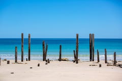 La playa portuaria hermosa de Willunga y las ruinas icónicas del embarcadero con aguas de la turquesa en un día soleado tranquilo imagen de archivo La playa portuaria hermosa de Willunga y las ruinas icónicas del embarcadero con aguas de la turquesa en un día soleado tranquilo imagen de archivo