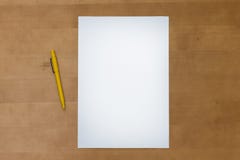 La pluma y el papel en blanco cubren en una tabla de madera Fotografía de archivo La pluma y el papel en blanco cubren en una tabla de madera Fotografía de archivo