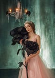La princesa joven abraza rosas fabulosas, enormes, negras en el estilo gótico La muchacha tiene una corona y un lujoso, borrachín foto de archivo libre de regalías La princesa joven abraza rosas fabulosas, enormes, negras en el estilo gótico La muchacha tiene una corona y un lujoso, borrachín foto de archivo libre de regalías