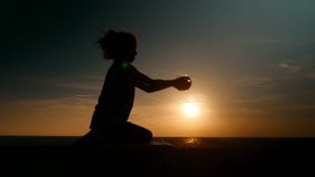 La puesta del sol en la niña de la silueta de la costa toma el pequeño fishbowl y mira la protección del medio ambiente del peque metrajes La puesta del sol en la niña de la silueta de la costa toma el pequeño fishbowl y mira la protección del medio ambiente del peque metrajes