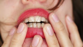 La ragazza alta vicina con le labbra rosse morde le sue dita stock footage La ragazza alta vicina con le labbra rosse morde le sue dita stock footage