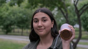 La ragazza castana allegra con capelli lunghi sta ballando nel parco alla musica mentre teneva un altoparlante portatile in sua m archivi video La ragazza castana allegra con capelli lunghi sta ballando nel parco alla musica mentre teneva un altoparlante portatile in sua m archivi video