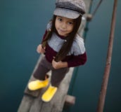 La ragazza del bambino sta sul ponte di legno e sui sorrisi su fondo della r immagini stock La ragazza del bambino sta sul ponte di legno e sui sorrisi su fondo della r immagini stock