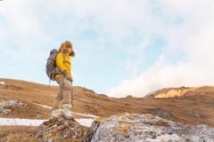 La ragazza di viaggiatore con zaino e sacco a pelo in occhiali da sole ed in un grande cappello di pelliccia nordico con uno zain Fotografia Stock La ragazza di viaggiatore con zaino e sacco a pelo in occhiali da sole ed in un grande cappello di pelliccia nordico con uno zain Fotografia Stock