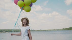 La ragazza graziosa mostra le emozioni felici con i palloni a disposizione al coustline archivi video La ragazza graziosa mostra le emozioni felici con i palloni a disposizione al coustline archivi video
