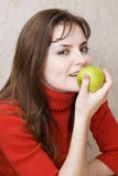 La ragazza mangia una mela fotografia stock libera da diritti La ragazza mangia una mela fotografia stock libera da diritti