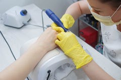 La ragazza nel servizio del chiodo del salone Allineamento dei chiodi facendo uso di una macchina elettrica immagine stock libera da diritti La ragazza nel servizio del chiodo del salone Allineamento dei chiodi facendo uso di una macchina elettrica immagine stock libera da diritti