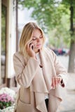 La ragazza sta esaminando l'orologio e sta parlando sul telefono fotografia stock La ragazza sta esaminando l'orologio e sta parlando sul telefono fotografia stock