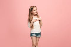 La ragazza teenager felice che sta e che sorride contro il fondo rosa fotografia stock La ragazza teenager felice che sta e che sorride contro il fondo rosa fotografia stock