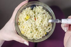 La ragazza tiene la lastra di vetro delle tagliatelle fotografia stock La ragazza tiene la lastra di vetro delle tagliatelle fotografia stock