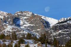 La regolazione della luna dietro i picchi di montagna nevosi in Rocky Mountain National Park immagine stock libera da diritti La regolazione della luna dietro i picchi di montagna nevosi in Rocky Mountain National Park immagine stock libera da diritti