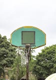 La reparaci?n rota del aro de baloncesto trabaja temporalmente el ?rbol y el cielo borrosos del fondo fotografía de archivo La reparaci?n rota del aro de baloncesto trabaja temporalmente el ?rbol y el cielo borrosos del fondo fotografía de archivo