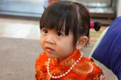 La robe chinoise rouge, se ferment vers le haut de la petite fille asiatique heureuse dans la robe traditionnelle chinoise An neu images stock La robe chinoise rouge, se ferment vers le haut de la petite fille asiatique heureuse dans la robe traditionnelle chinoise An neu images stock