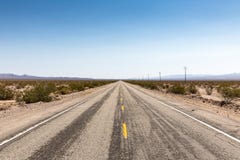 La ruta polvorienta 66 de la carretera lleva a través del desierto de mojave, Californ foto de archivo La ruta polvorienta 66 de la carretera lleva a través del desierto de mojave, Californ foto de archivo