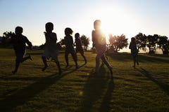 La scuola elementare profilata scherza il funzionamento in un campo fotografie stock libere da diritti La scuola elementare profilata scherza il funzionamento in un campo fotografie stock libere da diritti