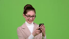 La señora del negocio mira las fotos en su smartphone Pantalla verde Cámara lenta almacen de metraje de vídeo La señora del negocio mira las fotos en su smartphone Pantalla verde Cámara lenta almacen de metraje de vídeo