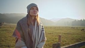 La señora delgada agradable está bebiendo té caliente y está disfrutando de la naturaleza en el pueblo en caída metrajes La señora delgada agradable está bebiendo té caliente y está disfrutando de la naturaleza en el pueblo en caída metrajes