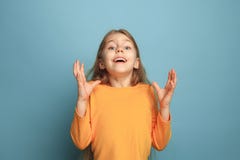 La sorpresa, la felicidad, la alegría, la victoria, el éxito y la suerte Muchacha adolescente en un fondo azul Expresiones facial fotografía de archivo La sorpresa, la felicidad, la alegría, la victoria, el éxito y la suerte Muchacha adolescente en un fondo azul Expresiones facial fotografía de archivo