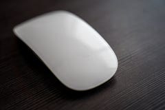 La souris sans fil blanche se trouve sur une table noire avec la réflexion indirecte image stock La souris sans fil blanche se trouve sur une table noire avec la réflexion indirecte image stock
