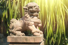 La statue chinoise de lion dans un temple de porcelaine avec le vert pousse des feuilles backgroud photographie stock libre de droits La statue chinoise de lion dans un temple de porcelaine avec le vert pousse des feuilles backgroud photographie stock libre de droits