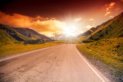La strada nelle montagne abbellisce con il tramonto luminoso fotografie stock La strada nelle montagne abbellisce con il tramonto luminoso fotografie stock