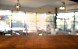 La table en bois foncée vide devant le résumé a brouillé le fond de bokeh du restaurant peut être employé pour l'affichage ou le images libres de droits La table en bois foncée vide devant le résumé a brouillé le fond de bokeh du restaurant peut être employé pour l'affichage ou le images libres de droits