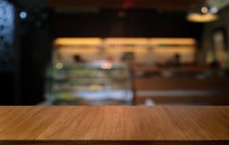 La tavola di legno scura vuota davanti all'estratto ha offuscato il fondo del bokeh del ristorante Può essere usato per esposizio fotografia stock La tavola di legno scura vuota davanti all'estratto ha offuscato il fondo del bokeh del ristorante Può essere usato per esposizio fotografia stock