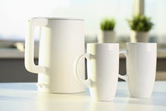 La teiera e due tazze d'avanguardia sono sulla tavola per fotografia stock La teiera e due tazze d'avanguardia sono sulla tavola per fotografia stock