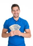 La tenuta dell'uomo ci ha smazzati valuta di carta fotografie stock libere da diritti La tenuta dell'uomo ci ha smazzati valuta di carta fotografie stock libere da diritti
