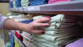 La tienda cercana de la mujer caucásica deja de lado elegir la toalla en primer de la tienda almacen de video La tienda cercana de la mujer caucásica deja de lado elegir la toalla en primer de la tienda almacen de video