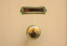 La vecchie cassetta della posta e manopola d'ottone della posta su un giallo hanno dipinto l'entrata principale fotografia stock libera da diritti La vecchie cassetta della posta e manopola d'ottone della posta su un giallo hanno dipinto l'entrata principale fotografia stock libera da diritti