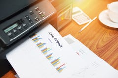 La venta de los informes de negocios de la impresión de la impresora y la pila de documentos divulgan la carta del gráfico en la foto de archivo La venta de los informes de negocios de la impresión de la impresora y la pila de documentos divulgan la carta del gráfico en la foto de archivo