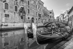 La vista blanco y negro de góndolas típicas parqueó en un canal veneciano, Venecia, Italia Imagenes de archivo La vista blanco y negro de góndolas típicas parqueó en un canal veneciano, Venecia, Italia Imagenes de archivo