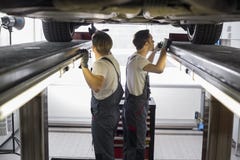 La vue de côté de l'entretien machine la voiture de examen dans l'atelier de réparations image libre de droits La vue de côté de l'entretien machine la voiture de examen dans l'atelier de réparations image libre de droits