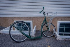 La vue extérieure des vélos amish de rouleau ou les scooters se penchent contre une maison photos libres de droits La vue extérieure des vélos amish de rouleau ou les scooters se penchent contre une maison photos libres de droits