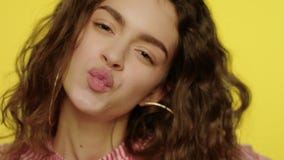 Labios que se besan de la mujer joven con las rebanadas del limón delante de ojos almacen de metraje de vídeo Labios que se besan de la mujer joven con las rebanadas del limón delante de ojos almacen de metraje de vídeo