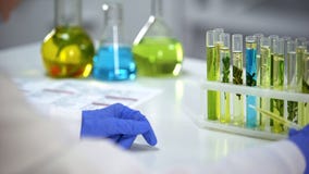 Laboranckiego pracownika mienia wkraplacz z wazeliniarskim żółtym cieczem, kosmetologia ekstrakt zdjęcie stock Laboranckiego pracownika mienia wkraplacz z wazeliniarskim żółtym cieczem, kosmetologia ekstrakt zdjęcie stock