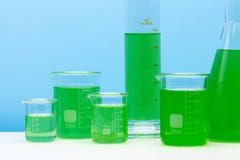 Laboratoriumexponeringsglasuppsättning som fylls med den gröna vikten fotografering för bildbyråer Laboratoriumexponeringsglasuppsättning som fylls med den gröna vikten fotografering för bildbyråer