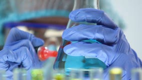 Laborchemiker-Markierungsflasche mit blauer Flüssigkeit, Haushaltschemikalienproduktion stock footage Laborchemiker-Markierungsflasche mit blauer Flüssigkeit, Haushaltschemikalienproduktion stock footage