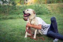 Labrador på gräset med hans ledar- tonåring royaltyfri fotografi Labrador på gräset med hans ledar- tonåring royaltyfri fotografi